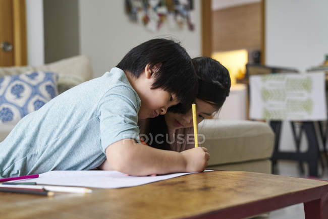 Siblings drawing and colouring at home — Stock Photo
