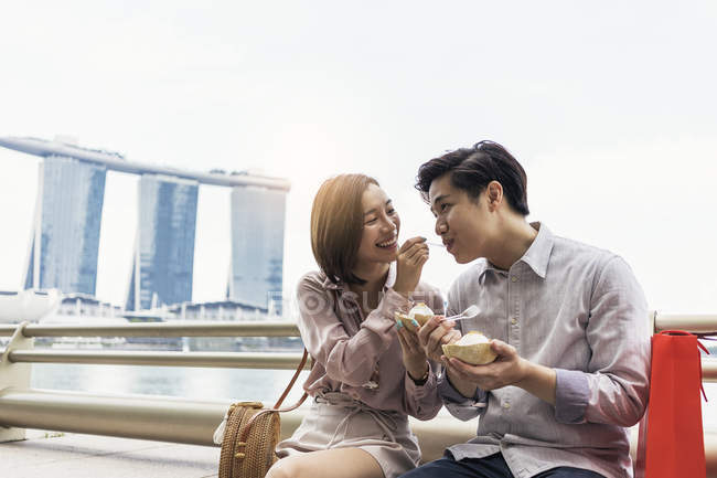 Joven asiático pareja compartir helado juntos en Singapur - foto de stock