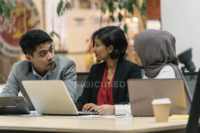 Giovani uomini d'affari multiculturali che lavorano con dispositivi digitali in uffici moderni — Foto stock