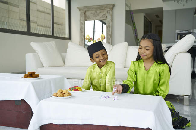 Молоді азіатські братів і сестер святкування Харі Райян разом в домашніх умовах — стокове фото