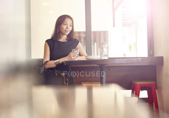 Jovem bela mulher asiática sentado no restaurante — Fotografia de Stock
