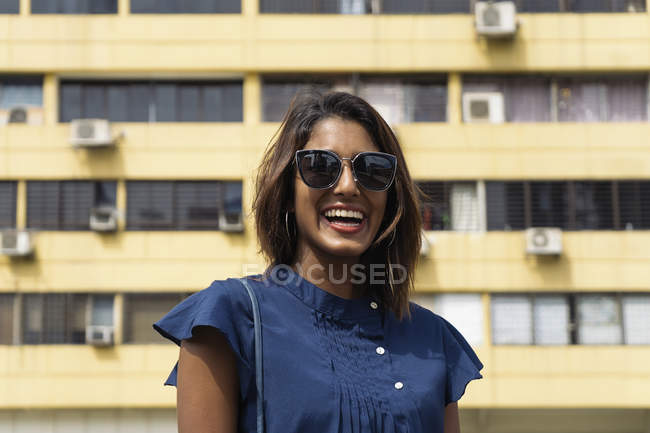 Молода випадкова азіатська дівчина посміхається в сонцезахисних окулярах — стокове фото