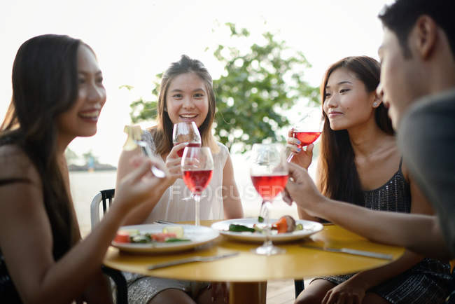 Beautiful young asian friends having drink — Stock Photo