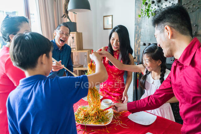 Felice famiglia asiatica insieme mangiare a casa — Foto stock