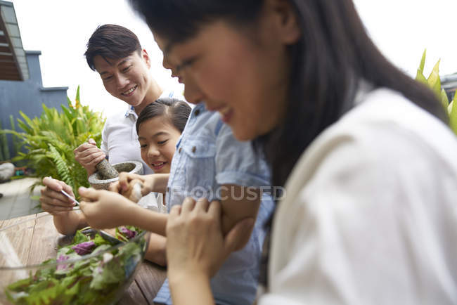 Feliz asiático familia preparación comida juntos en casa - foto de stock