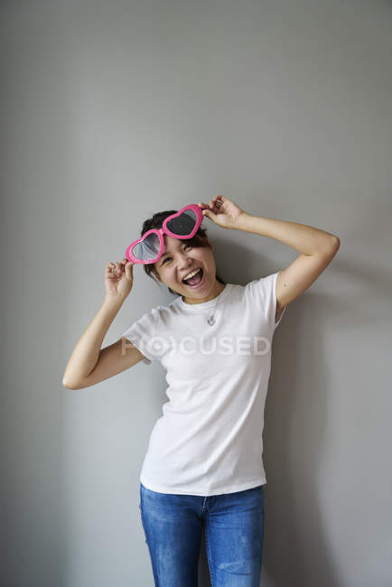 Jovem mulher se divertindo com seus óculos divertidos — Fotografia de Stock