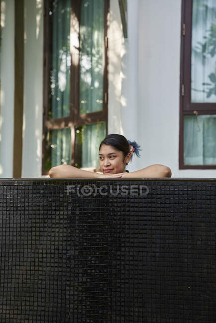 Jeune femme asiatique relaxante dans une piscine — Photo de stock