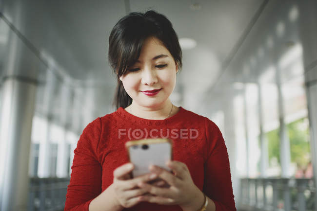 Jovem bela mulher asiática usando smartphone — Fotografia de Stock