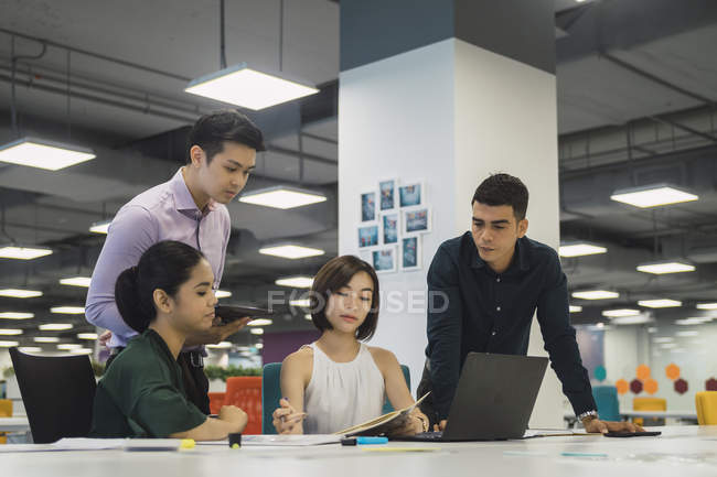 Jeunes gens d'affaires asiatiques au travail dans un bureau moderne — Photo de stock