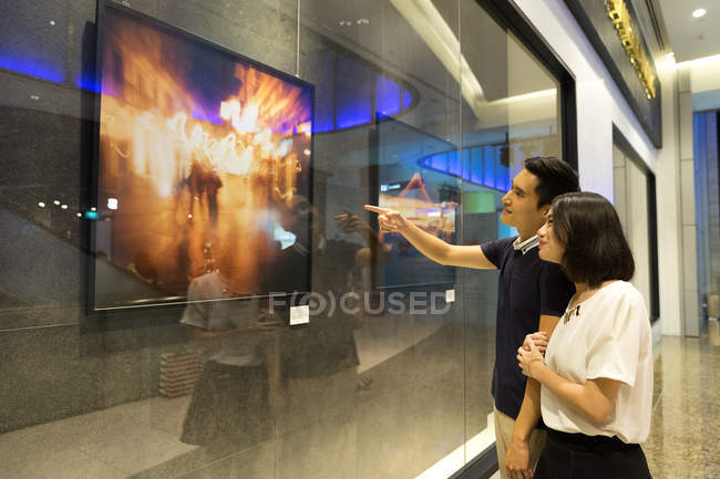 Young asian couple looking at stuff in shopping mall — Stock Photo