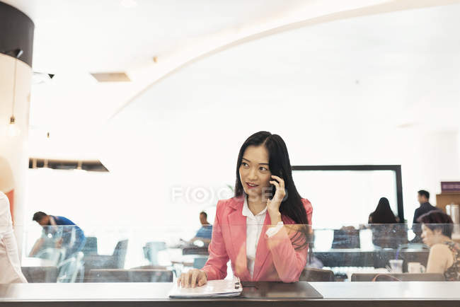 Giovane attraente asiatico donna utilizzando smartphone in shopping mall — Foto stock