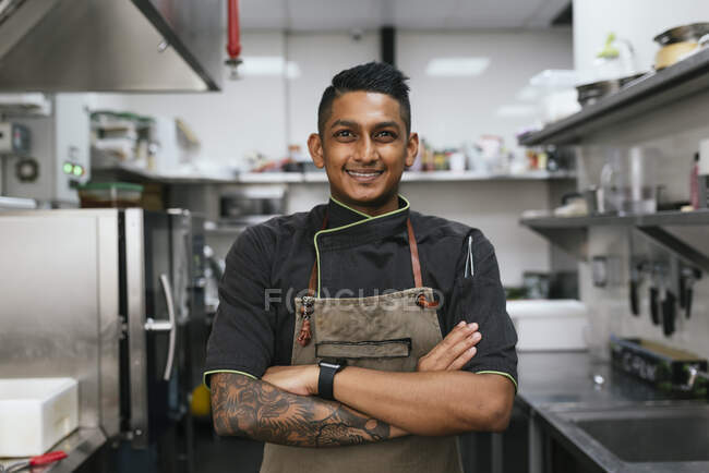 Joven asiático chef cocina en restaurante cocina - foto de stock
