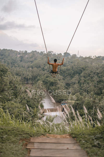 Резервну копію для подання молодий чоловік на гойдалки в Балі — стокове фото