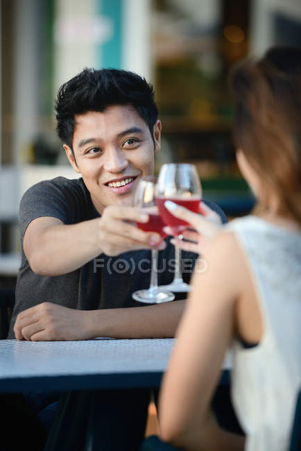 Joven atractivo asiático pareja teniendo beber juntos - foto de stock