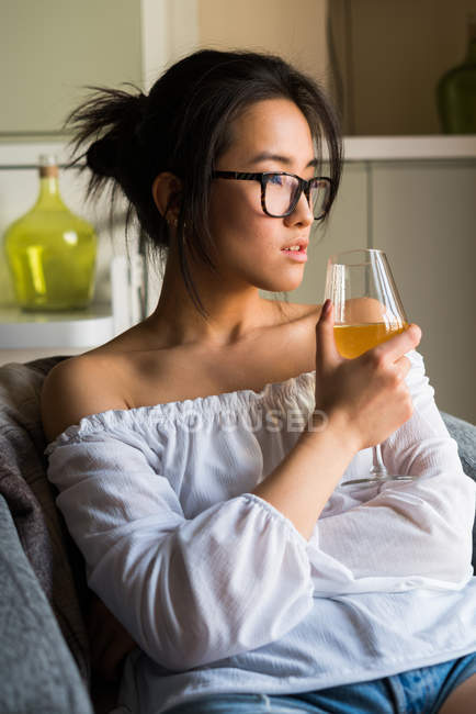 Jovem chinesa bebendo vinho e usando óculos — Fotografia de Stock