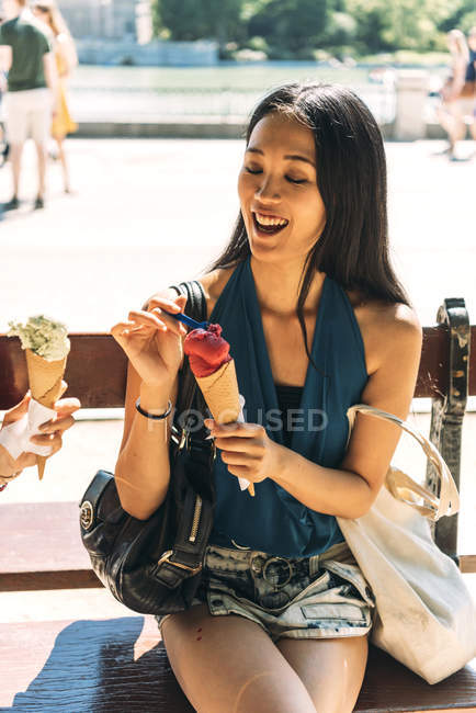Азійка їсть морозиво в парку. — стокове фото