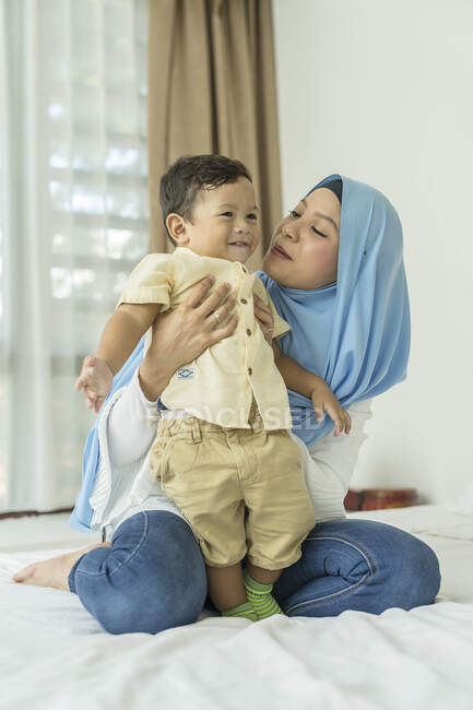 Madre e bambino che si abbracciano in camera — Foto stock