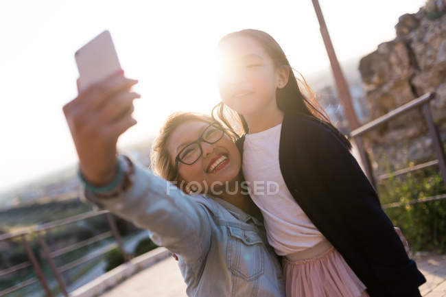 Счастливая молодая мать со своей дочерью делает селфи с телефоном-камерой — стоковое фото