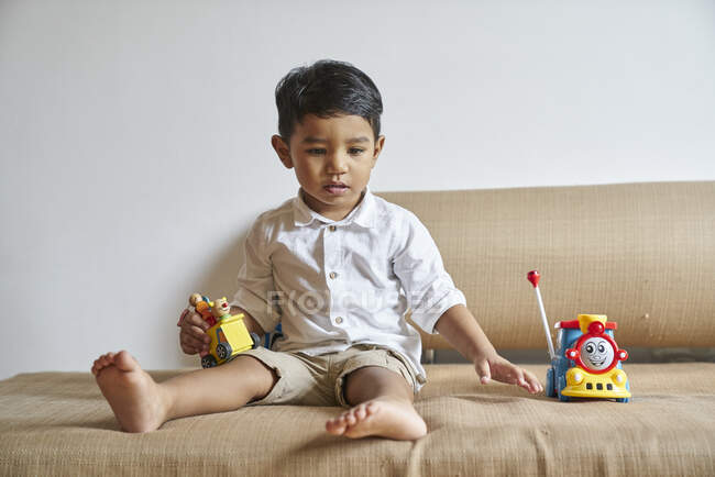 Menino brincando no sofá — Fotografia de Stock