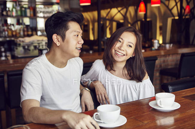 Happy young asian couple having date in cafe — Stock Photo