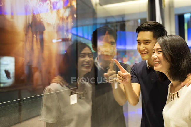 Young asian couple looking at stuff in shopping mall — Stock Photo