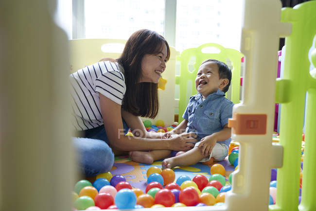 Mère collage avec bébé jouer dans la salle de jeux — Photo de stock