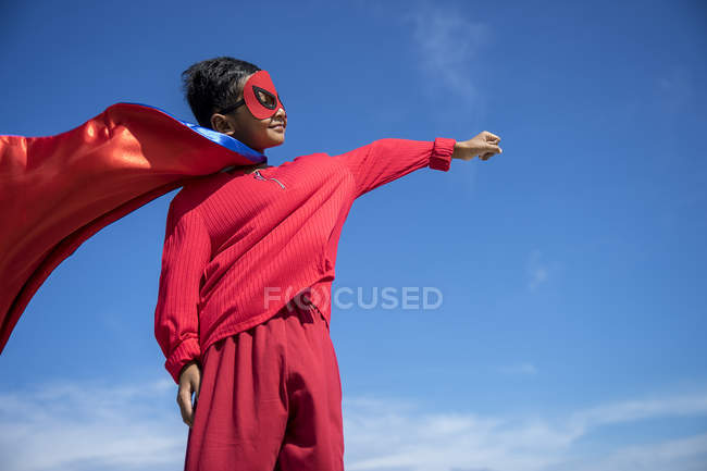 Superhelden-Kind vor blauem Himmel. — Stockfoto
