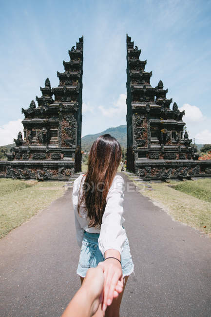 Rückansicht einer jungen Frau, die die Hand ihres Partners in Bali hält — Stockfoto