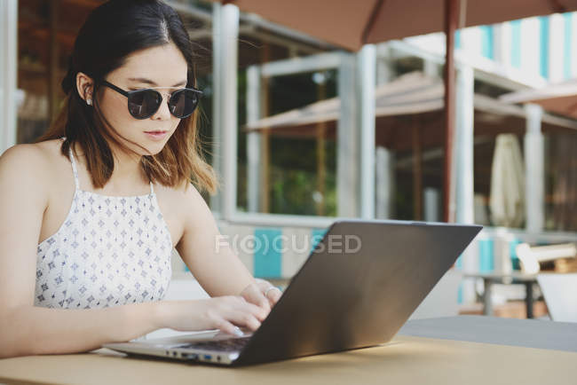 Giovane attraente asiatico donna utilizzando laptop — Foto stock