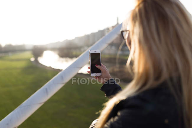 Ritratto di bella giovane donna che usa il suo cellulare per strada. — Foto stock