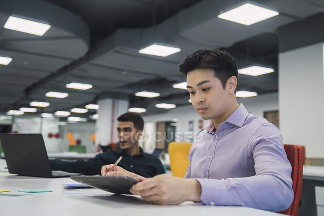 Jeunes hommes d'affaires asiatiques travaillant dans un bureau moderne — Photo de stock
