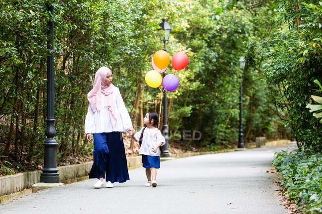 Mutter und Kind spazieren gemütlich durch den Park. — Stockfoto