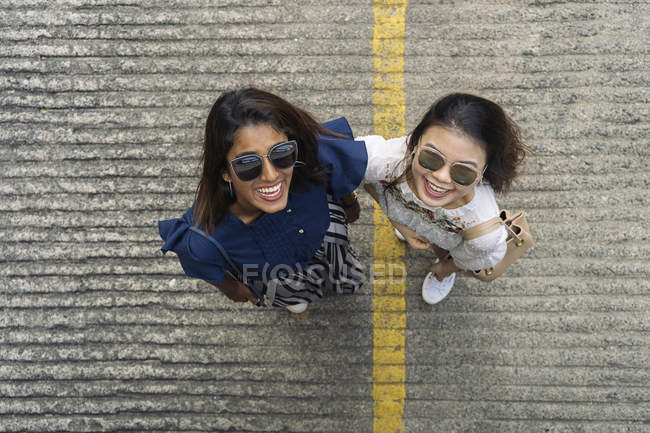 Young casual asian girls looking up at camera — Stock Photo