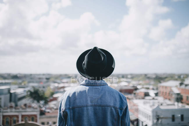 Молодий чоловік дивиться на місто з вершини — стокове фото