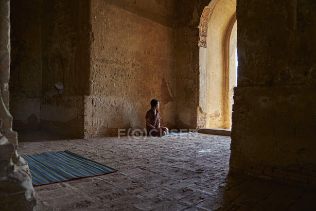Молодая леди покоится внутри древнего храма, Пагода, Баган, Мьянма — стоковое фото