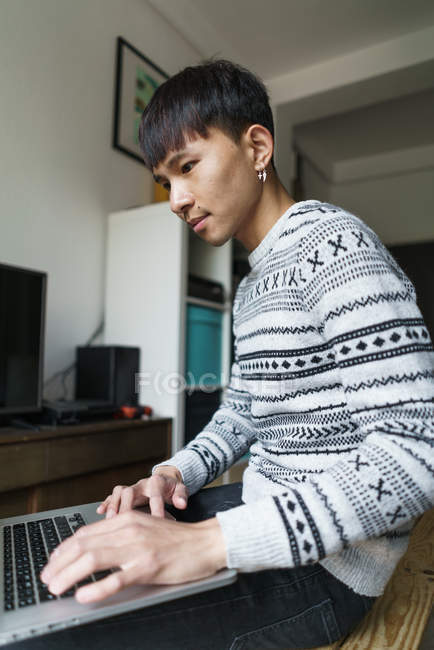 Азіатський юнак, використання ноутбука на дому — стокове фото