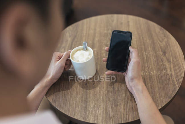 Cropped image of asian man using smartphone — Stock Photo