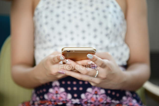 Cropped image of woman using smartphone — Stock Photo