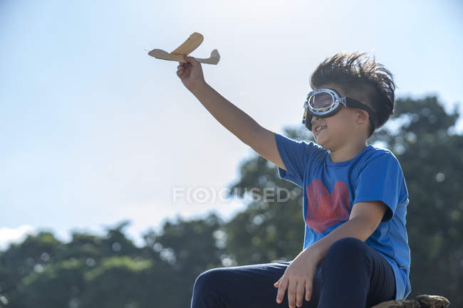 Superhero kid playing with a toy airplane — Stock Photo