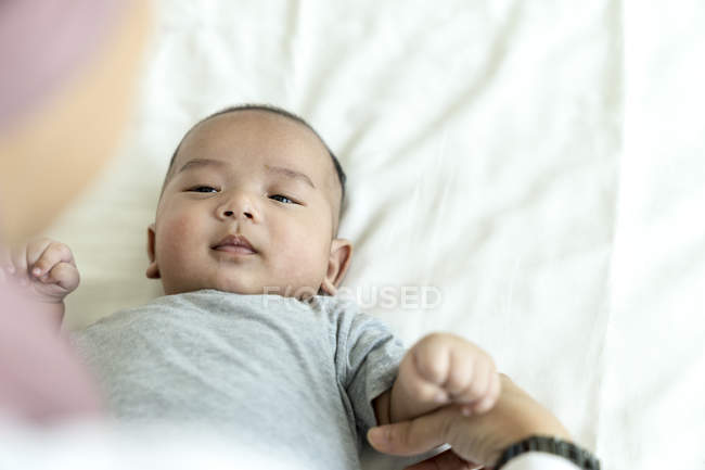 Closeup image of mother and asian baby on bed — Stock Photo