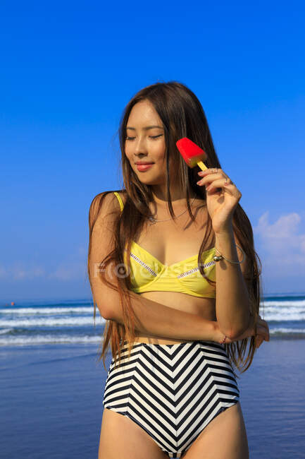 Азиатка на пляже в бикини с мороженым в руке . — стоковое фото