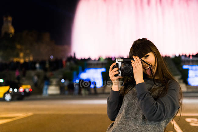 Jolie femme aux cheveux longs eurasiens avec caméra à Barcelone — Photo de stock