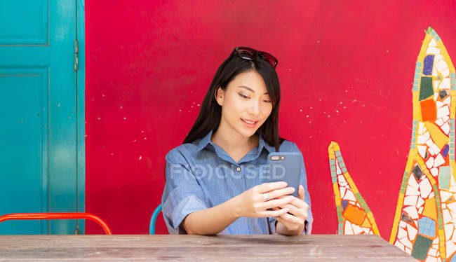 Приваблива доросла азіатська жінка використовує смартфон — стокове фото