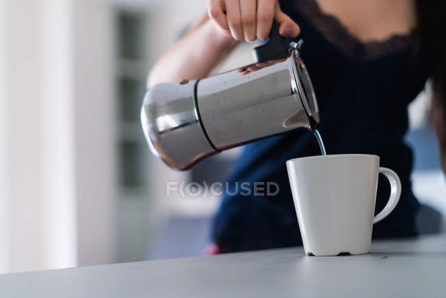 Frau serviert sich eine Tasse Tee in Detailaufnahme — Stockfoto