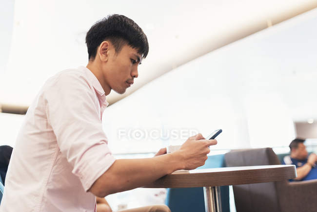 Привабливий молодий азіатський чоловік використовує смартфон — стокове фото