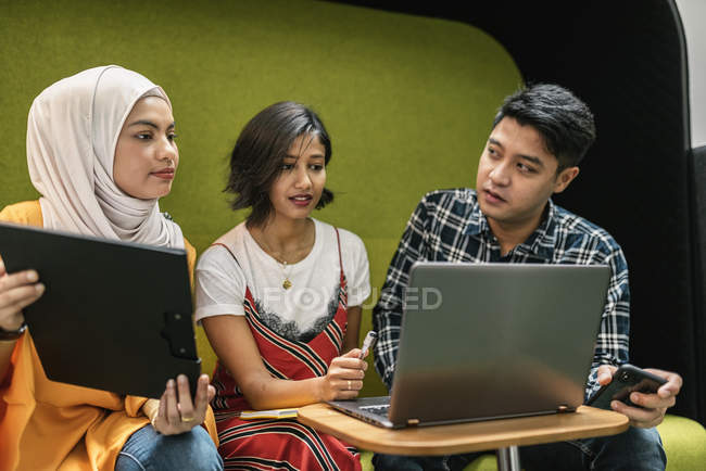 Young multicultural business people working with digital devices in modern office — Stock Photo