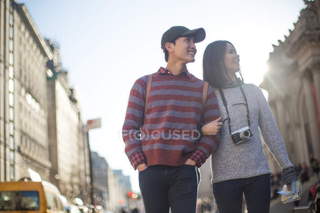Attractive tourist couple being playful while walking together in a landmark of the New York - The Metropolitan Museum of Art during a sunny day, outdoors. — Stock Photo