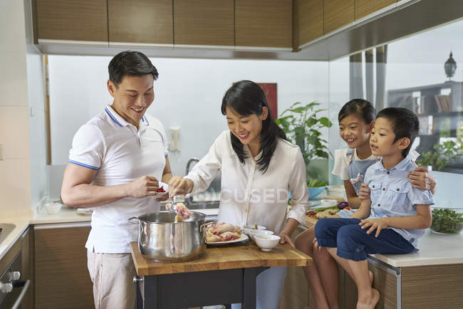 Feliz asiático familia preparación comida juntos en casa - foto de stock