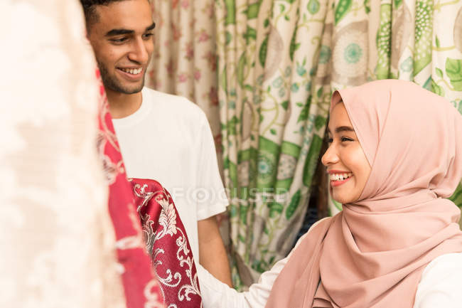 Молодая мусульманская пара покупает ткани в магазине — стоковое фото