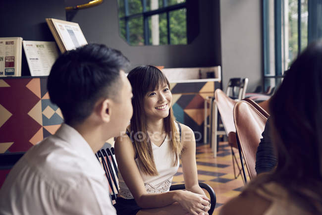 Company of young asian friends together in cafe — Stock Photo
